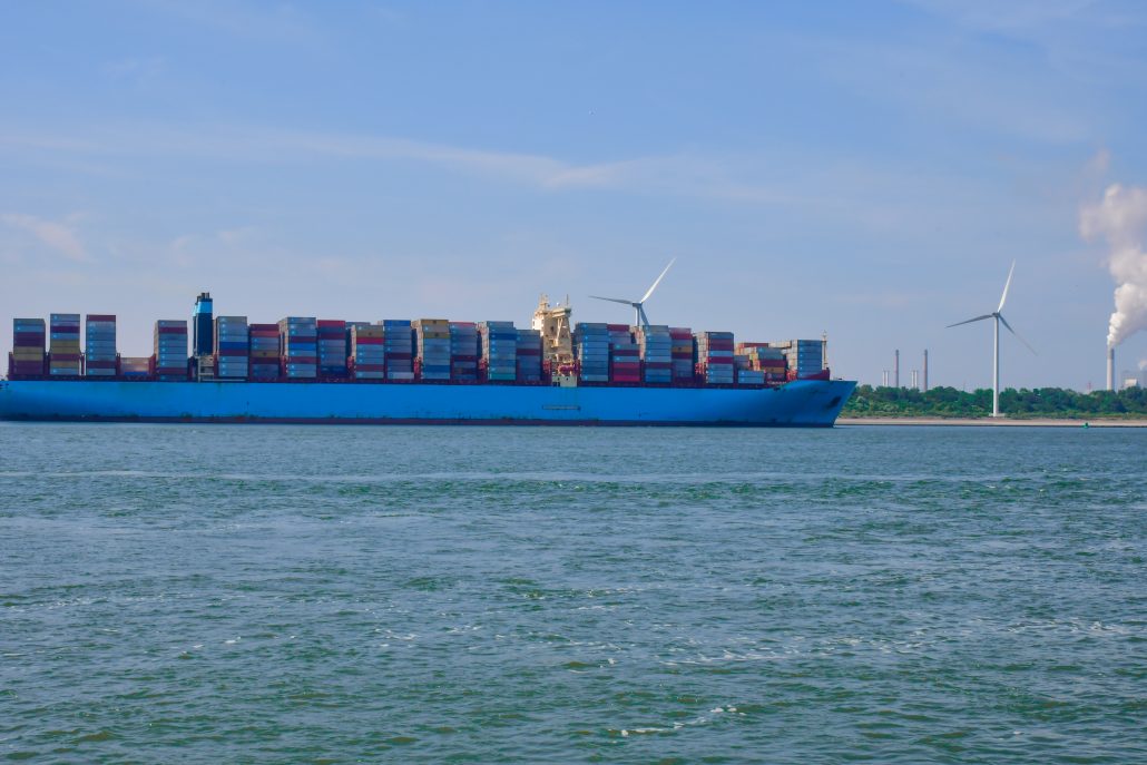 picture of container with behing a shore and wind farms