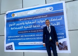 Mohamed Lemine in front of banner of aquaculture conference in Mauritania february 2023