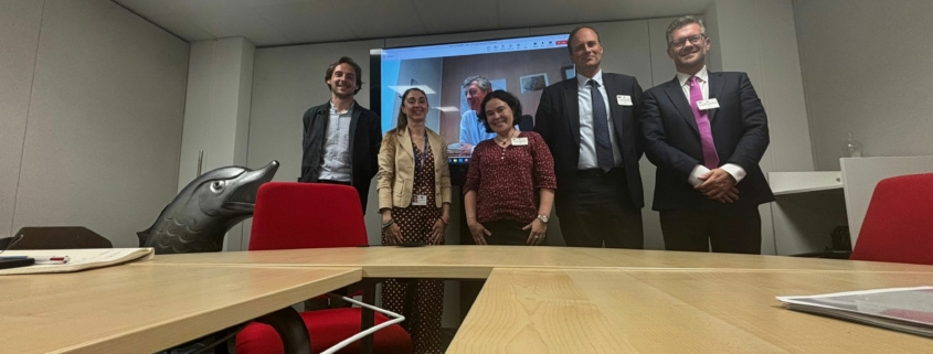 Group of people posing in an office room. decarbonsation meeting