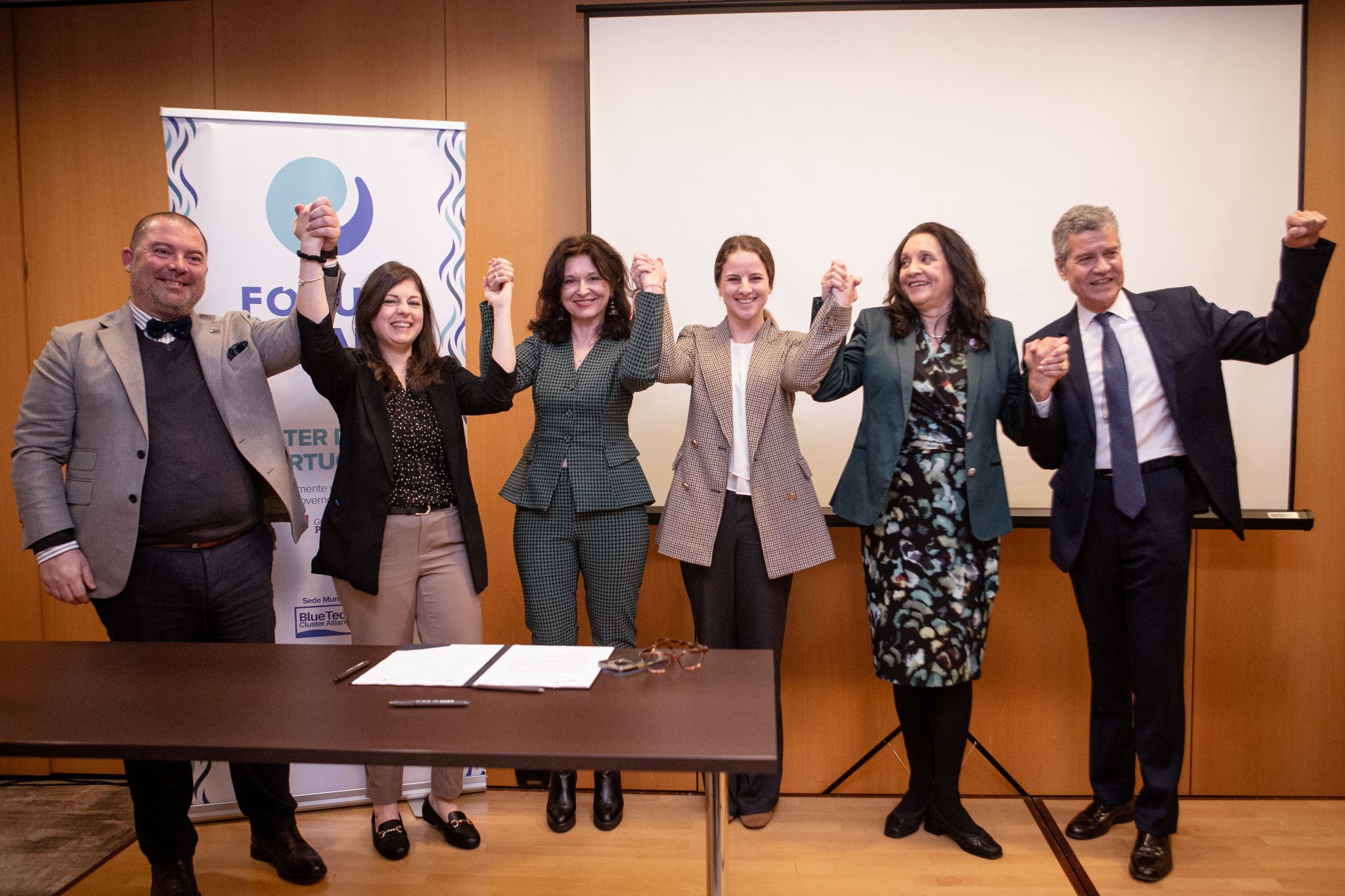 representatives from the MedBan partners holding and rasing hands to celebrate their commitment to the MedBAN mission