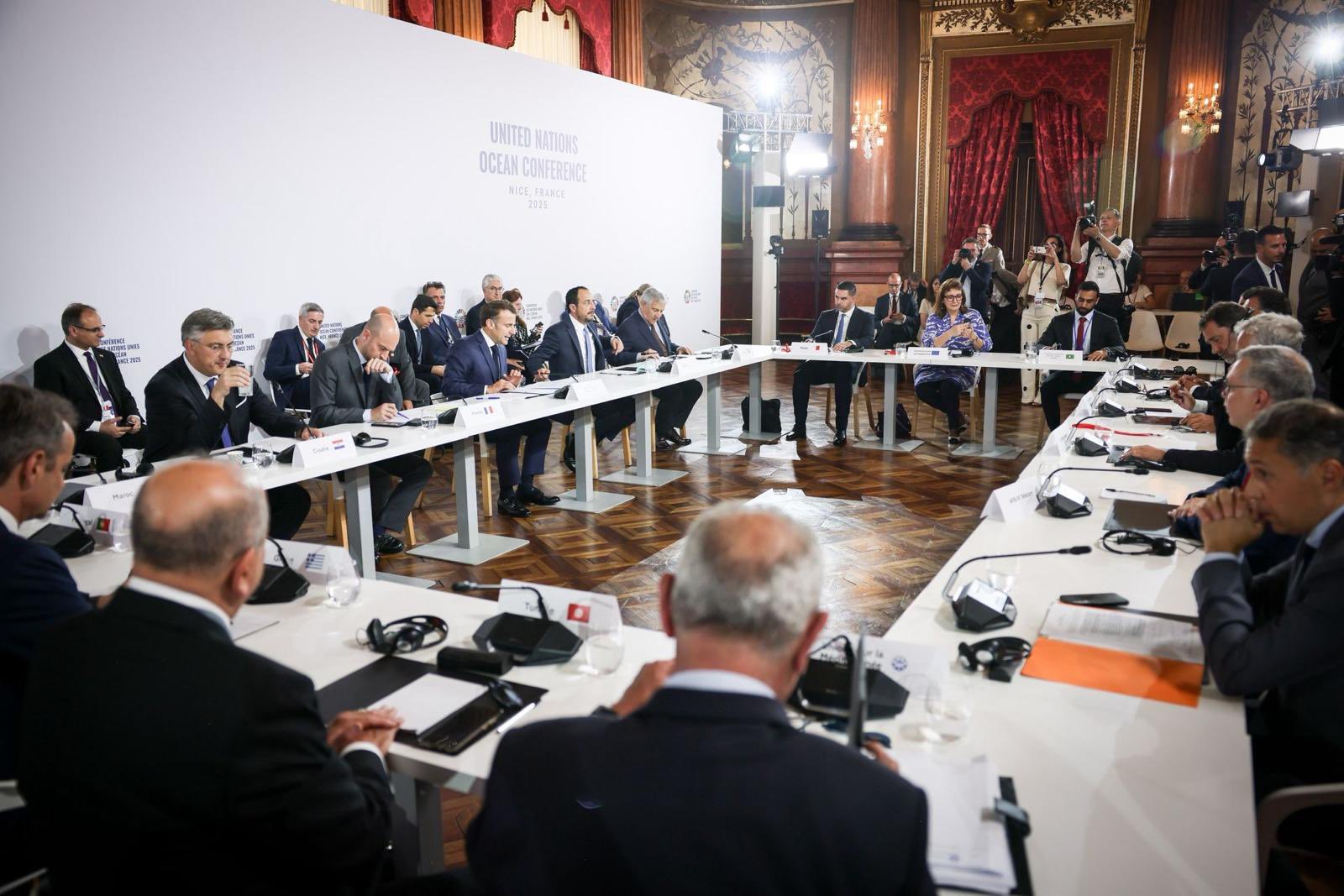 meeting with people seated at table against a United Nations Ocean Conference backdrop