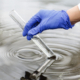 researcher holds test tube with water hand blue glove